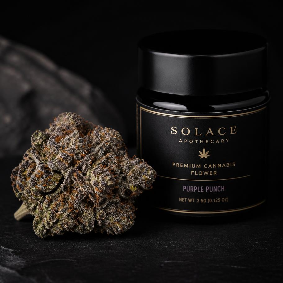 Dark green cannabis bud with purple edges beside a black jar